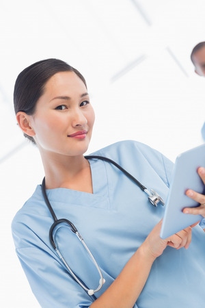 Portrait of a beautiful female surgeon using digital tablet in the hospitalの写真素材