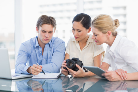 Young businessman and women working together at office deskの写真素材