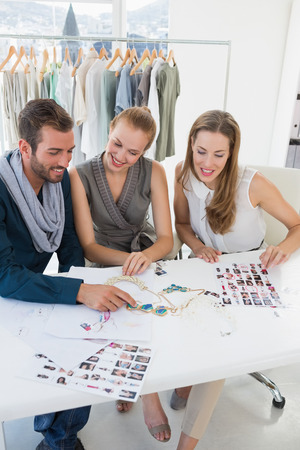 Three fashion designers discussing designs in a studioの写真素材