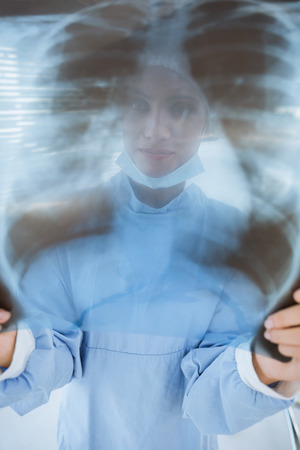 Close-up of a female surgeon examining blurred x-ray in the hospital