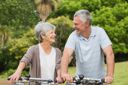 Portrait of a senior couple on cycle ride at the parkの写真素材