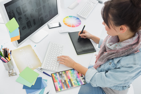 High angle view of an artist drawing something on graphic tablet at the office High angle view of an artist drawing something on graphic tablet at the office