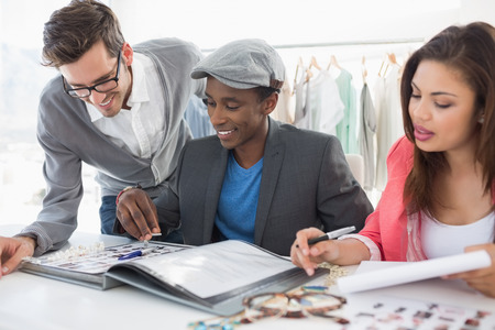 Group of fashion designers discussing designs in a studioの写真素材
