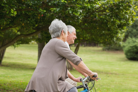 Side view of a senior couple on cycle ride in countrysideの写真素材