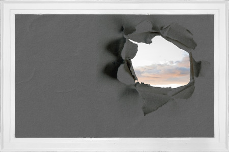 Rip on wall showing bright skyの写真素材