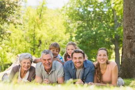 Portrait of an extended family lying on grass in the parkの写真素材
