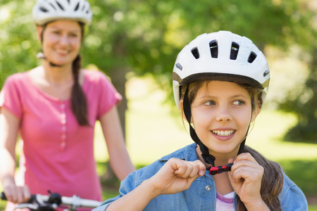 Portrait of a smiling woman with her daughter riding a bicycleの写真素材