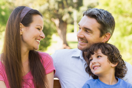 Close-up portrait of a smiling couple with son in the parkの写真素材
