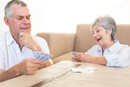 Senior couple playing cards at homeの写真素材