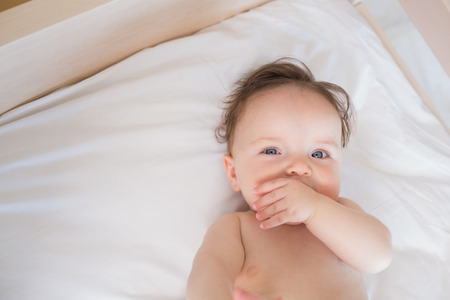High angle portrait of cute baby boy in bed