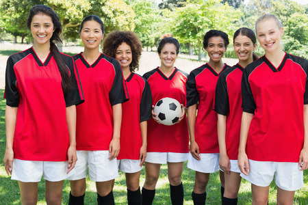 Portrait of happy female soccer team at parkの写真素材