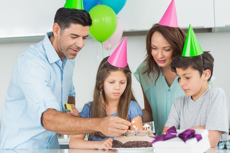 Portrait of a family of four with cake at a birthday partyの写真素材