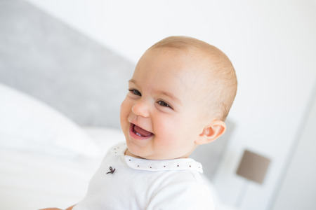 Closeup portrait of a cheerful cute baby over blurred backgroundの写真素材