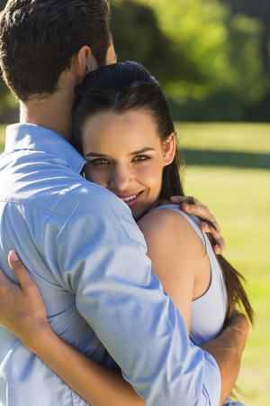 Side view of a young couple embracing at the parkの写真素材