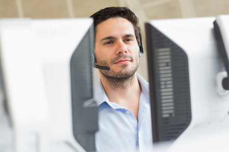 Male customer service representative using computer in call center