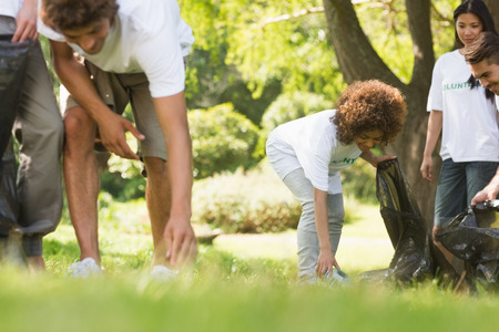 Team of young volunteers picking up litter in the park