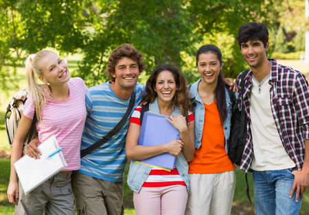 Group portrait of happy college friends standing in the campus