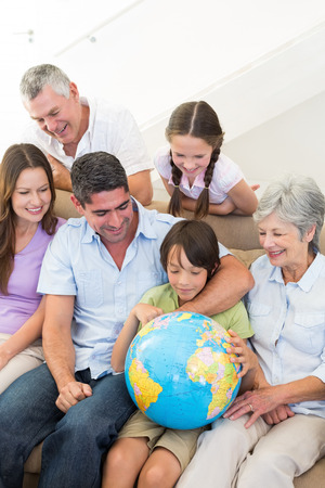Multigeneration family looking at globe in houseの写真素材