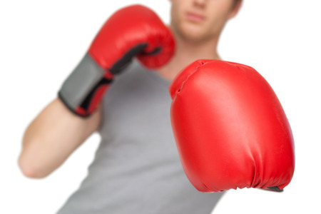 Athletic man wearing red boxing gloves on white backgroundの写真素材