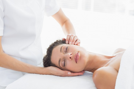 Beautiful woman receiving head massage in health spaの写真素材