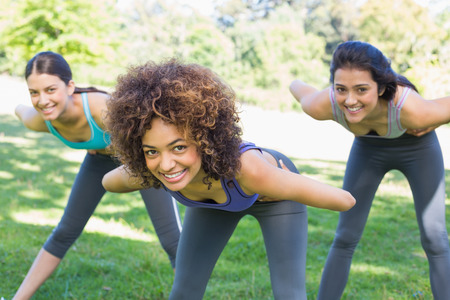 Portrait of smiling sporty women exercising in parkの写真素材