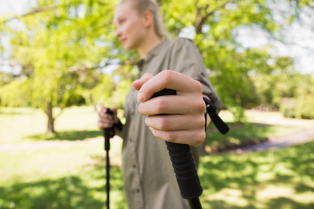 Side view of a beautiful young woman Nordic walking in the parkの写真素材