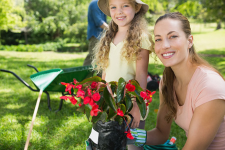 Portrait of a smiling mother and daughter engaged in gardening