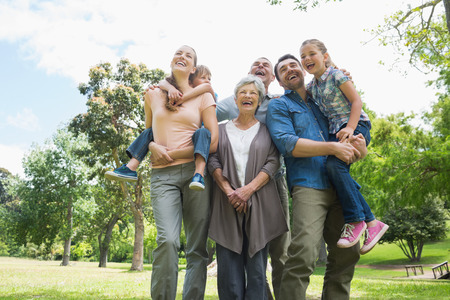 Low angle view of cheerful extended family standing at the park