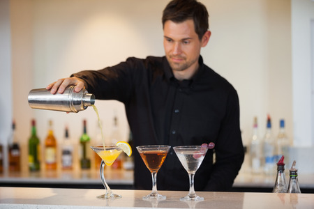 Bartender pouring cocktails at the barの写真素材