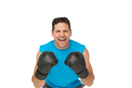 Close-up portrait of a determined male boxer screaming over white backgroundの写真素材