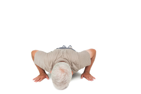 Senior man doing push ups over white backgroundの写真素材
