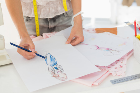Closeup mid section of a female fashion designer working on her designs in the studioの写真素材