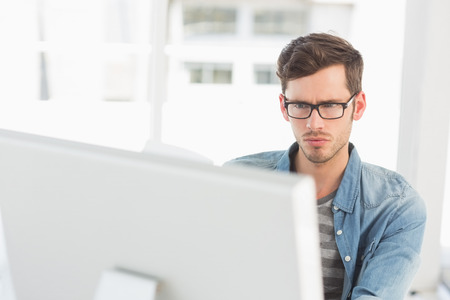 Concentrated young male artist using computer in the office