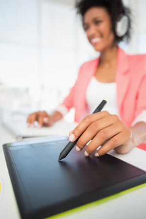 Casual female photo editor using graphics tablet in a bright officeの写真素材