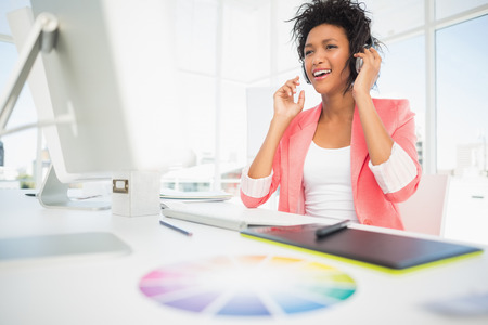 Casual female photo editor using computer in a bright officeの写真素材