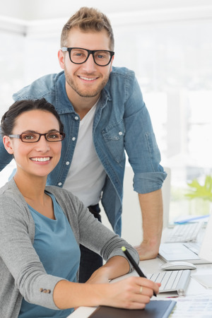 Young attractive design team at desk smiling at camera in creative officeの写真素材