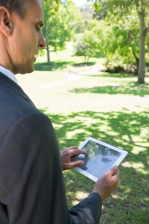 Businessman using tablet computer in parkの写真素材