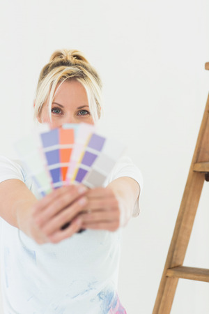 Portrait of a young woman holding blurred color swatches in a new houseの写真素材