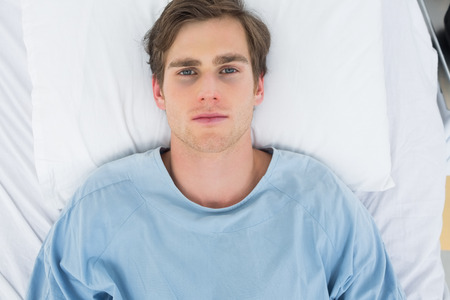 Overhead view of male patient lying in hospital bedの写真素材
