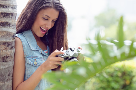 Stylish happy girl looking at her camera on a sunny dayの写真素材