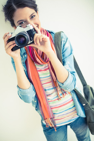 Attractive brunette taking a photograph on white backgroundの写真素材