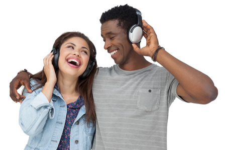 Portrait of a young couple enjoying music over white backgroundの写真素材