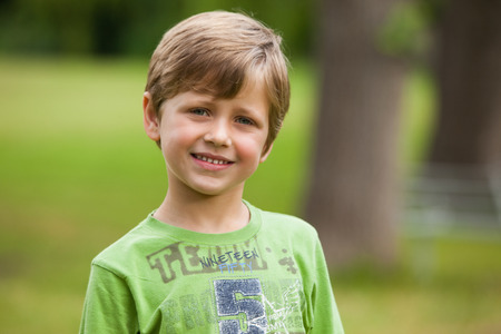 Portrait of a smiling young boy standing at the parkの写真素材