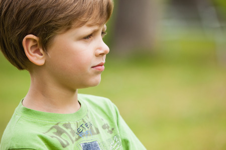 Side view of a serious young boy at the parkの写真素材