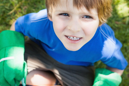 Close-up portrait of a young boy in gardening gloves at the parkの写真素材