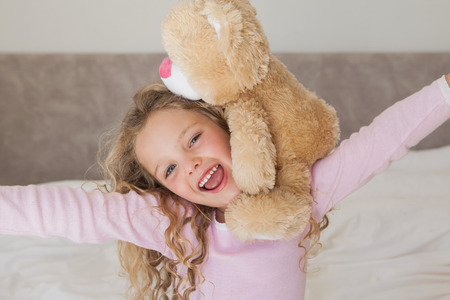 Close-up portrait of a young happy girl with stuffed toyの写真素材