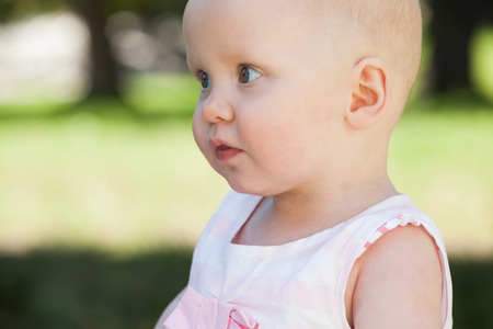 Close-up side view of a cute baby looking away at the park