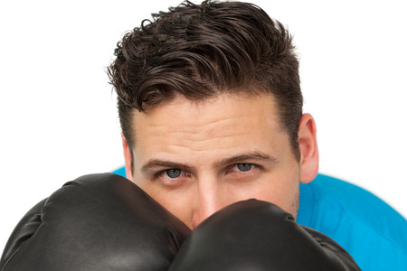 Close-up of a determined male boxer focused on his training over white background