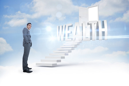 The word wealth and smiling businessman standing against steps leading to open door in the skyの写真素材