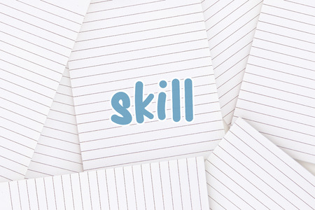 The word skill against lined paper strewn over surfaceの写真素材
